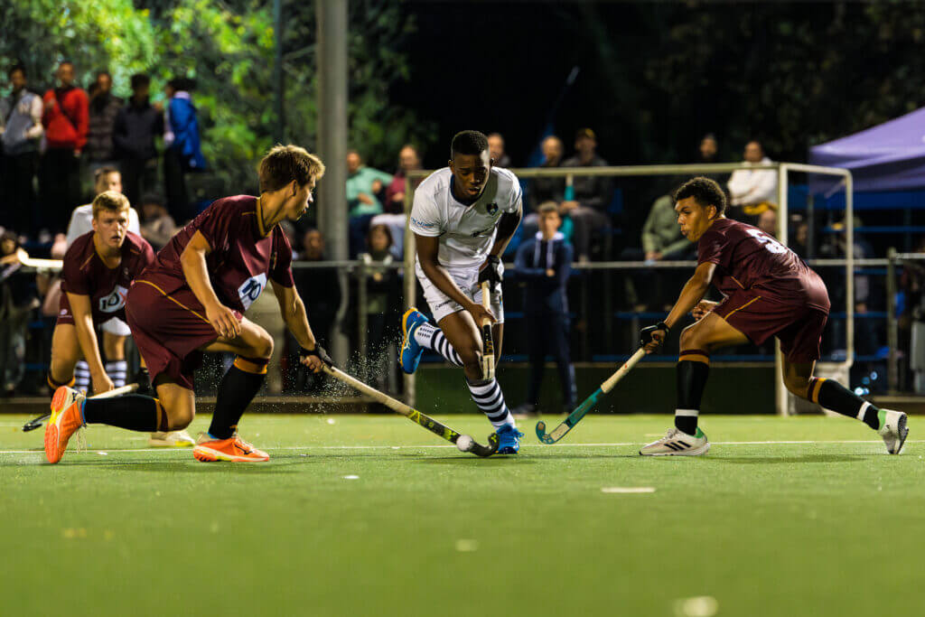 SACS's Litha Kraai charges in between two PRG players during their encounter at the Brewery Astroturf in Cape Town on 10 May 2024. Photo Credits: Ray Chaplin