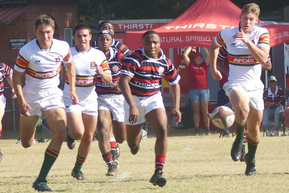 Maritzburg College centre Nkululeko Sithole is pursued by Affies' defenders as he kicks ahead on Goldstone's. Photo: Brad Morgan.