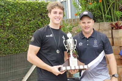 Hilton College 1st team captain, Andrew Schnell, receives the overall winners' trophy from Clifton College's Director of Water Polo, Shaun Ferreira. Photo: Brad Morgan.